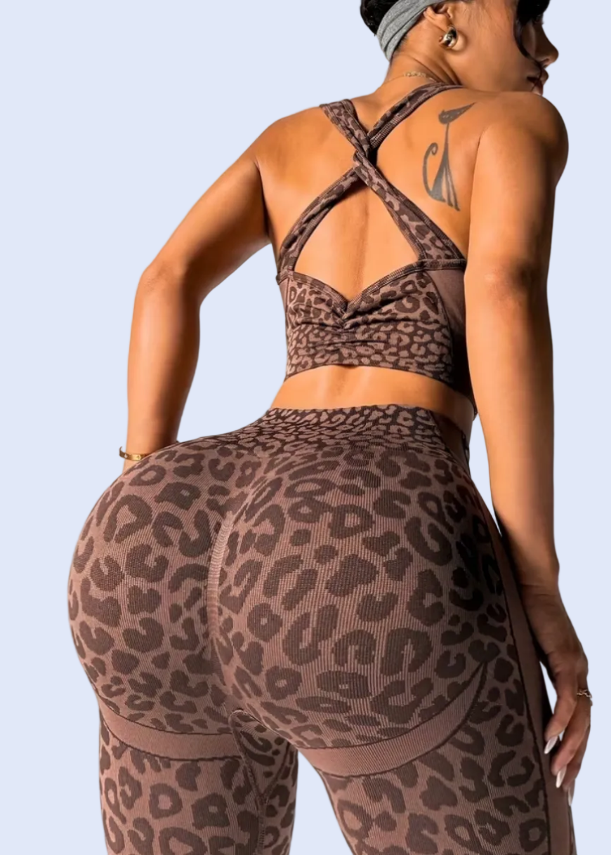 Person wearing leopard print athletic wear on a plain background