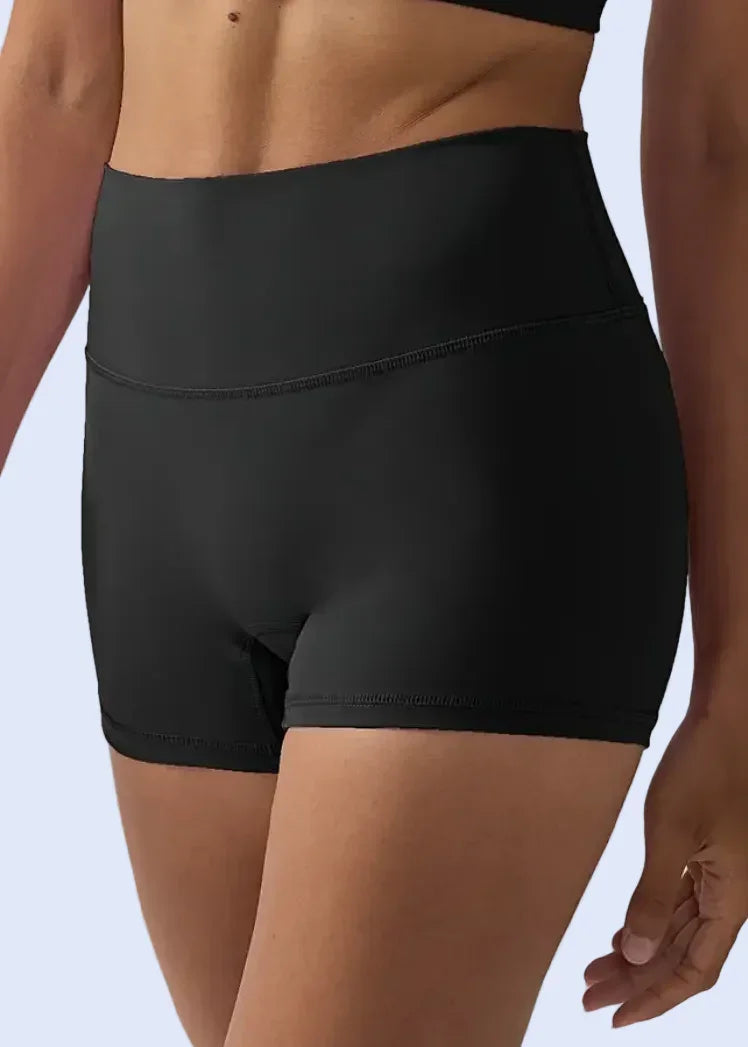 Person wearing black athletic shorts on a plain background