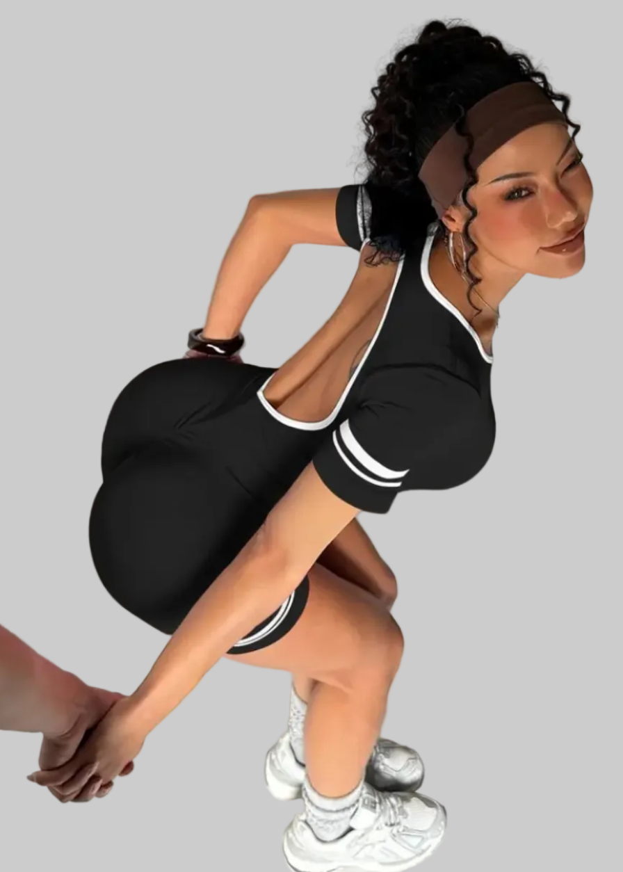 Woman in black athletic outfit posing against a plain background