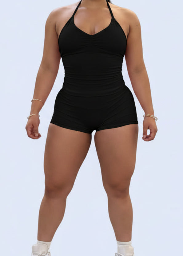 Person wearing a pink romper on a light blue background