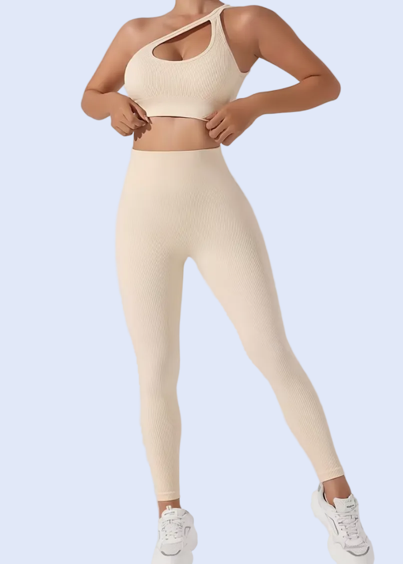 Woman wearing a beige sports bra and leggings on a white background
