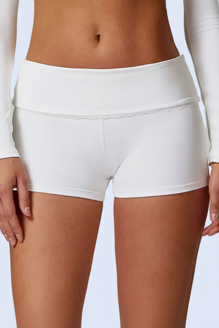 Person wearing white athletic shorts with a plain background