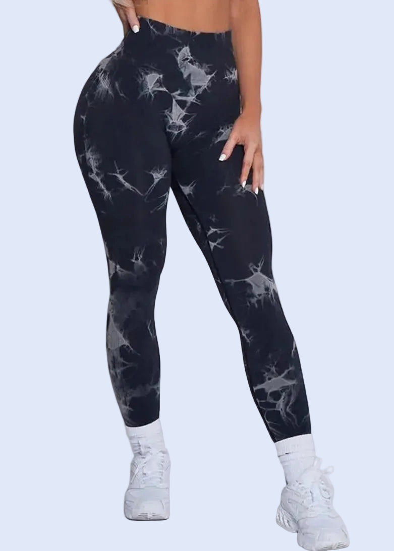 Person wearing black tie-dye leggings on a white background