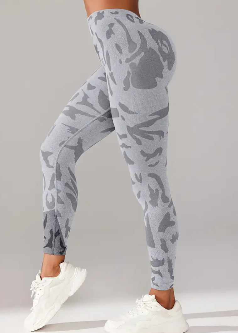 Person wearing gray camouflage leggings on a plain background