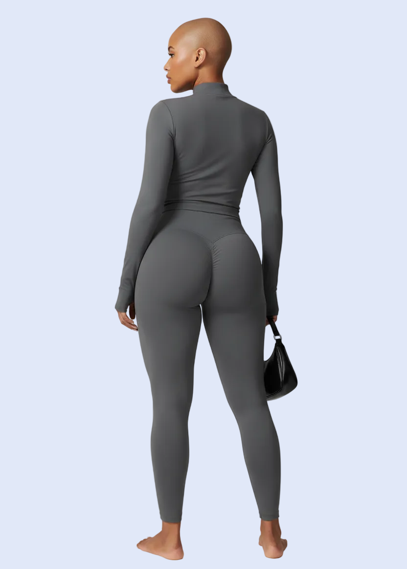 Person wearing a gray jumpsuit on a light gray background