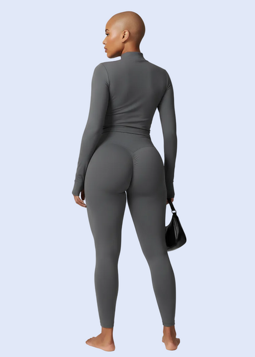 Person wearing a gray jumpsuit on a light gray background