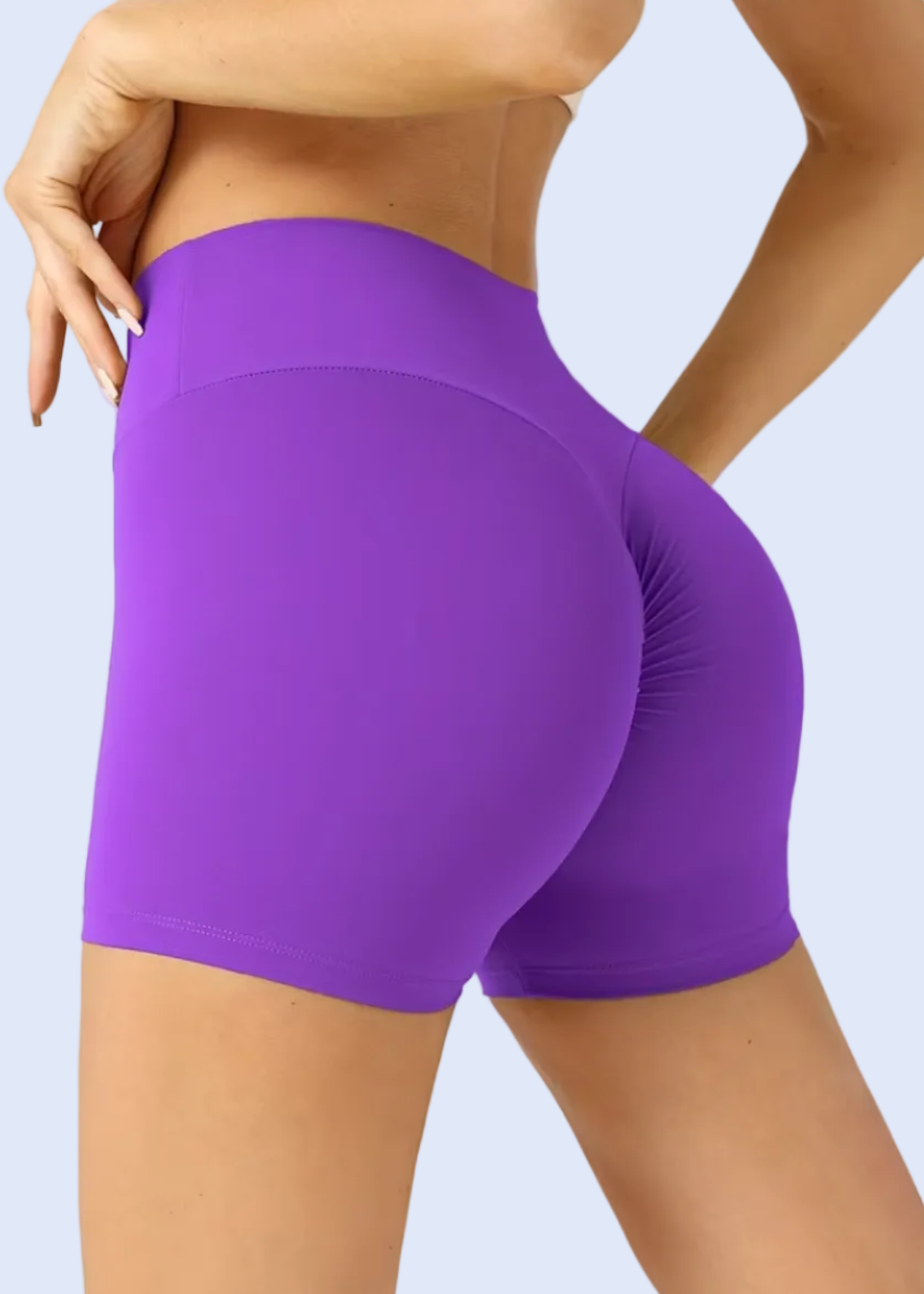 Purple athletic shorts worn by a person on a white background