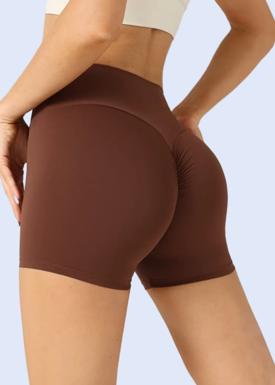 Brown athletic shorts worn by a person on a white background