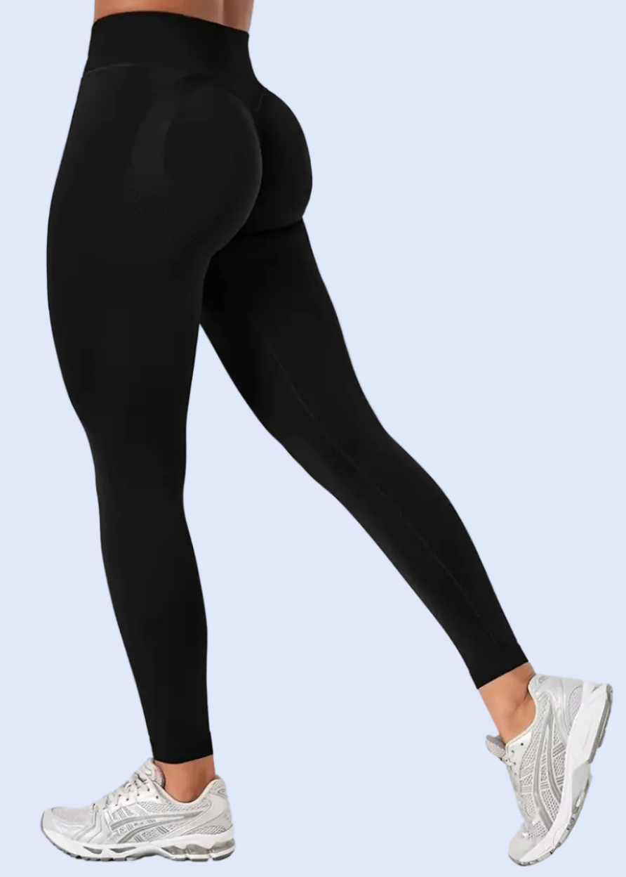 Person wearing black leggings and white sneakers on a white background