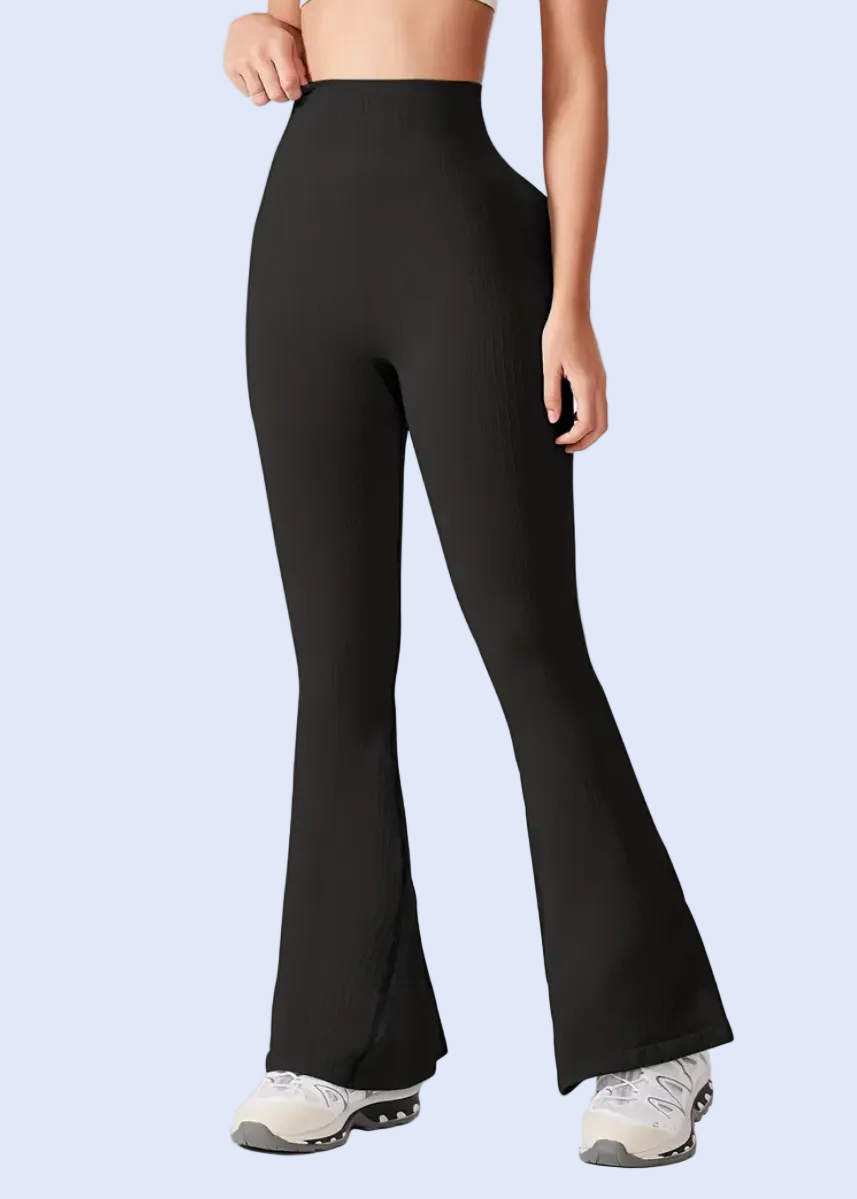 Person wearing black flared pants on a white background