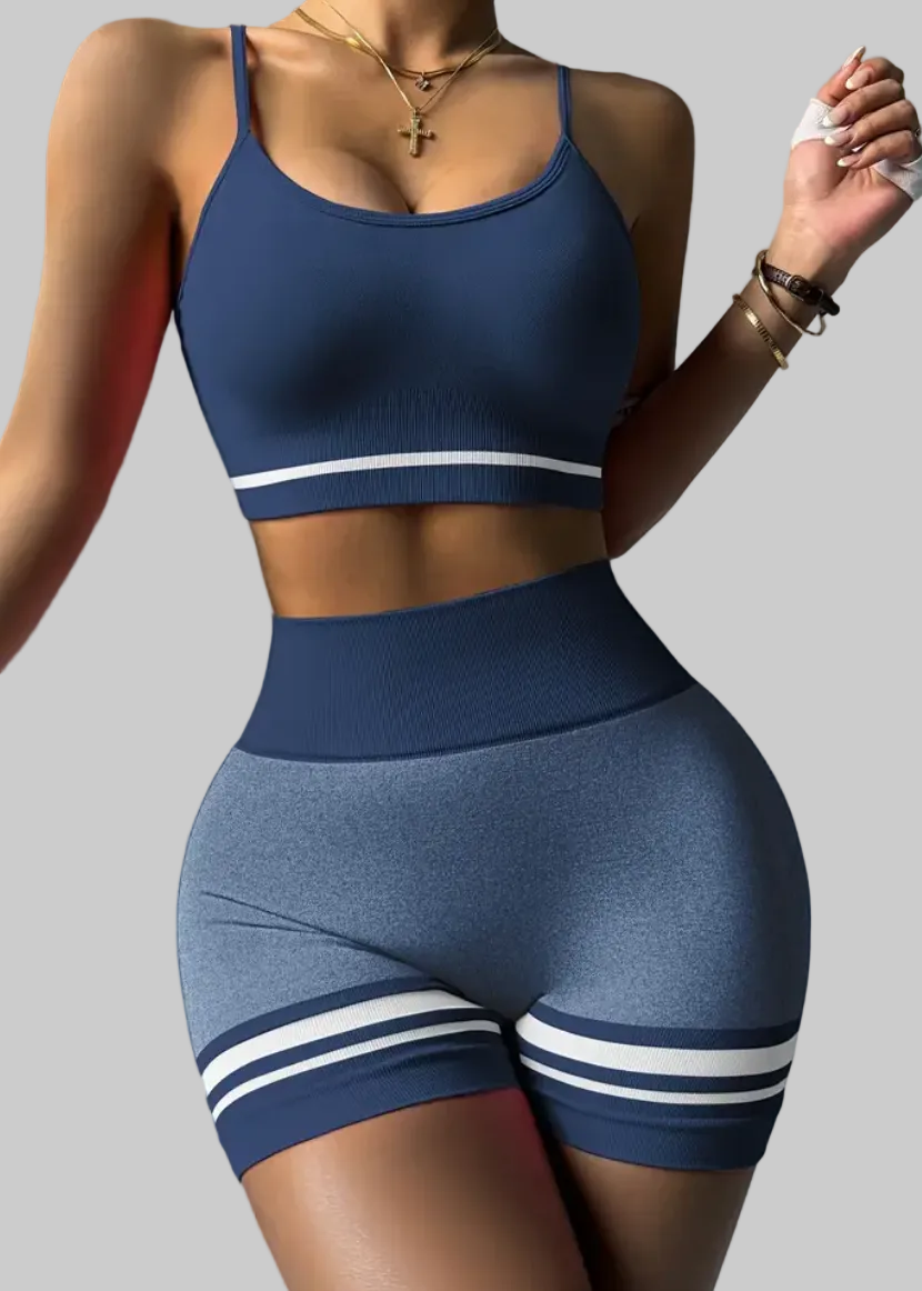 Woman wearing a blue athletic outfit with white stripes on a gray background