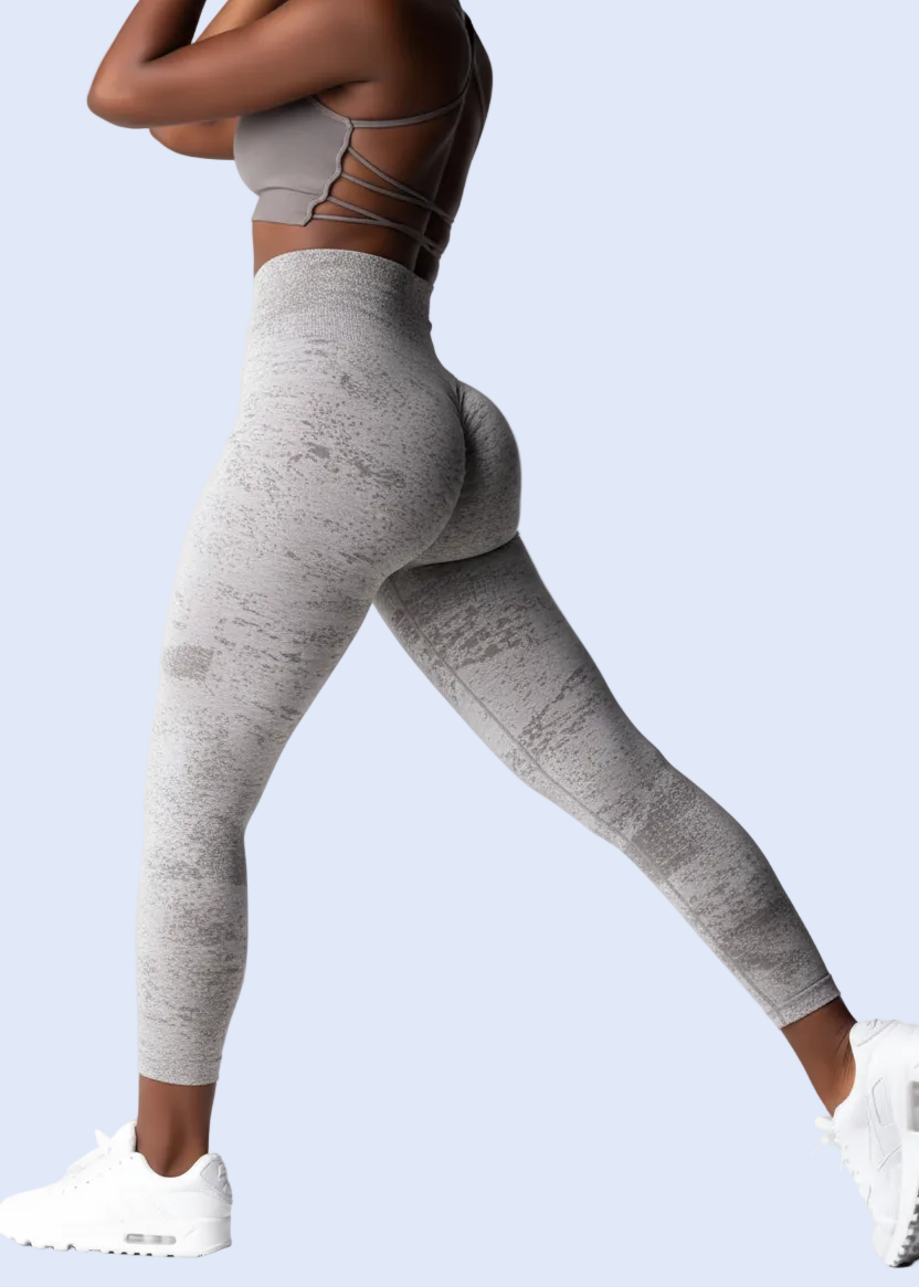 Person wearing gray leggings with a white background, showing product details.