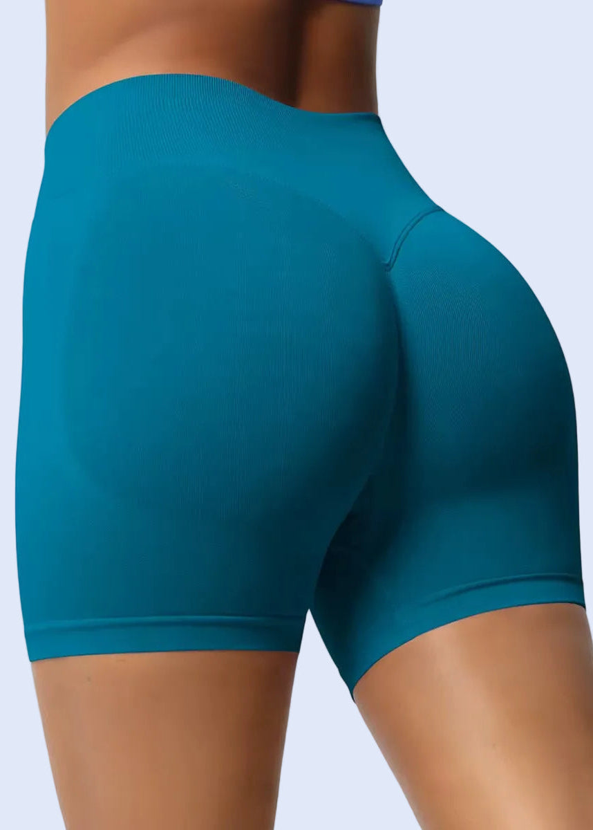 Teal athletic shorts worn by a person on a plain background