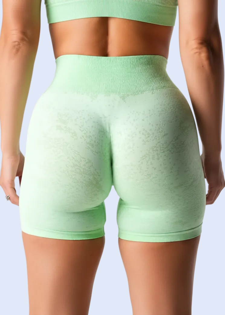 Person wearing light green athletic shorts on a white background