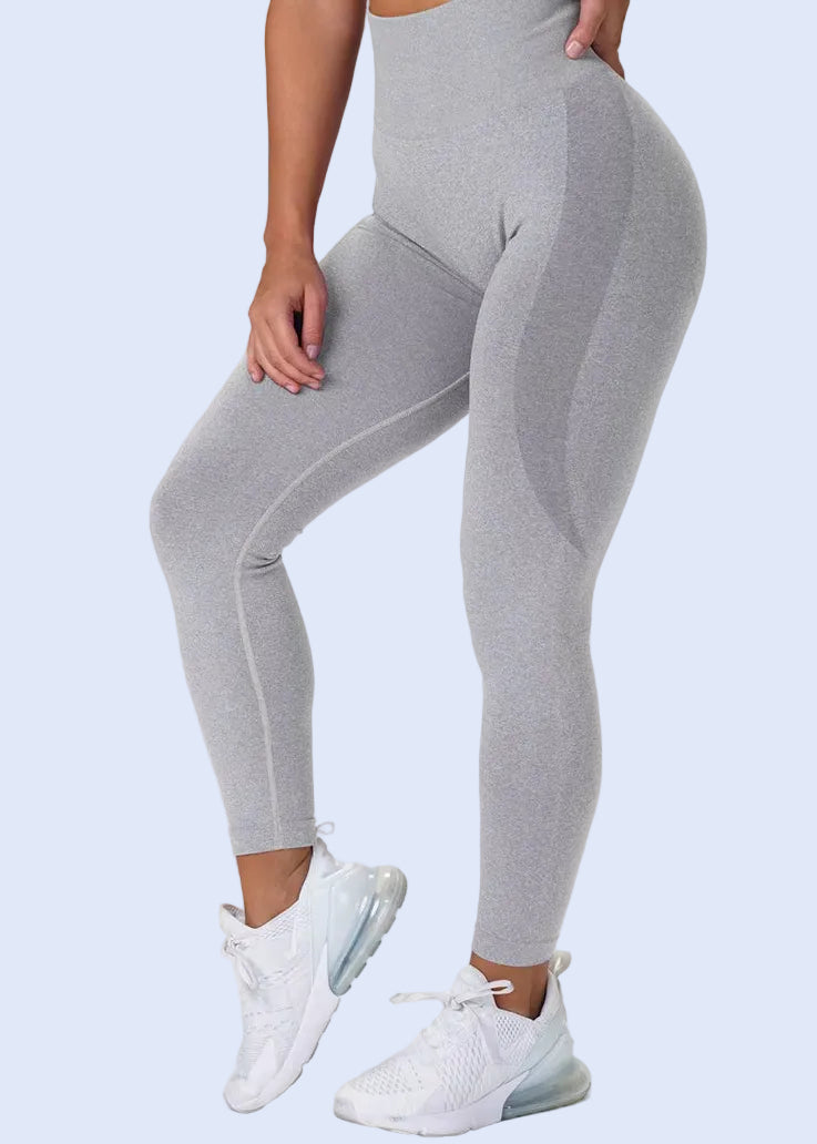 Gray leggings worn by a person on a white background