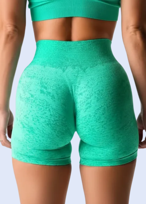 Person wearing teal athletic shorts and top on a plain background