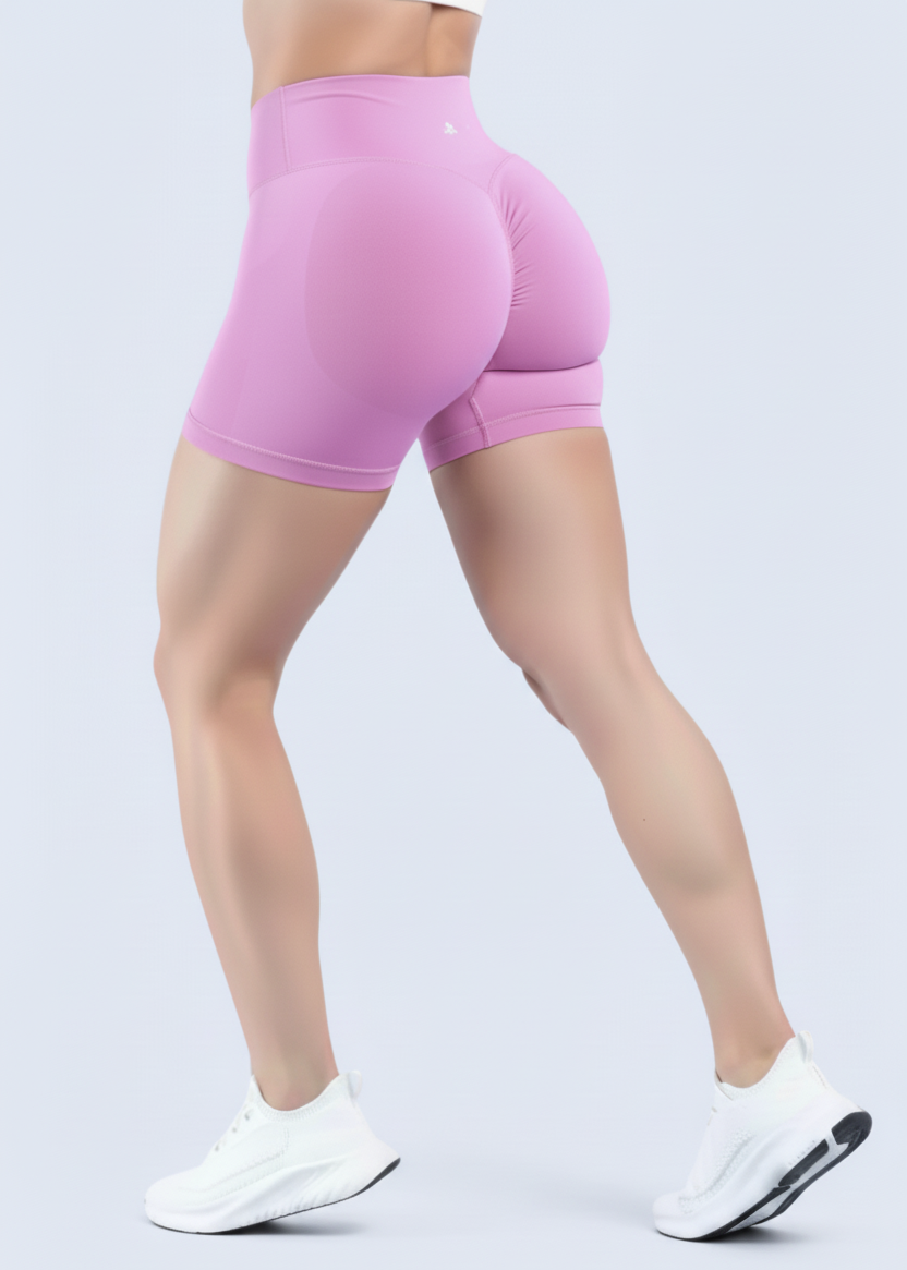 Person wearing pink high-waisted shorts on a light purple background