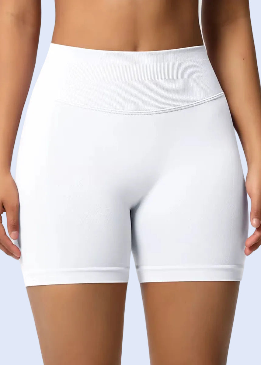 White athletic shorts worn by a person on a plain background
