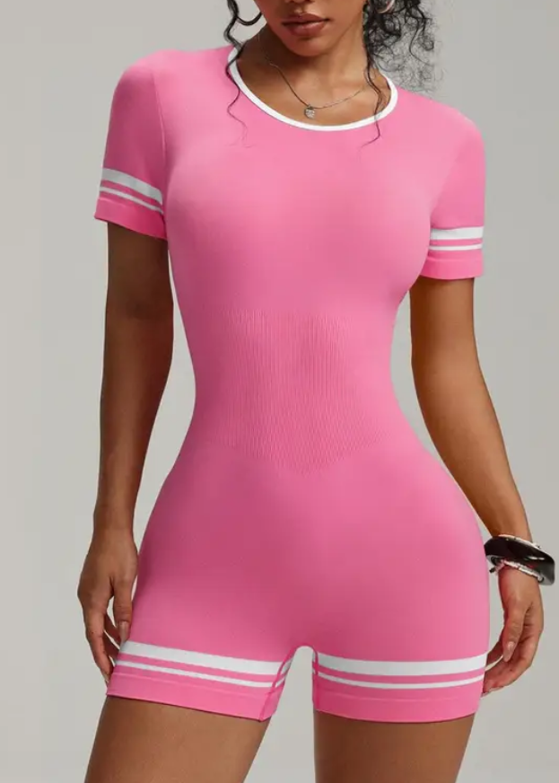 Woman wearing a pink outfit with white accents on a gray background