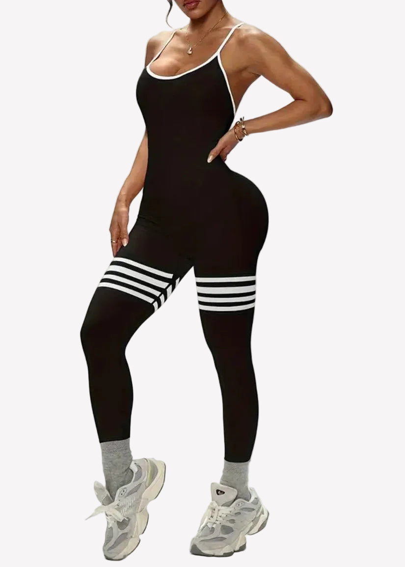 Person wearing a black outfit with white stripes on a plain background