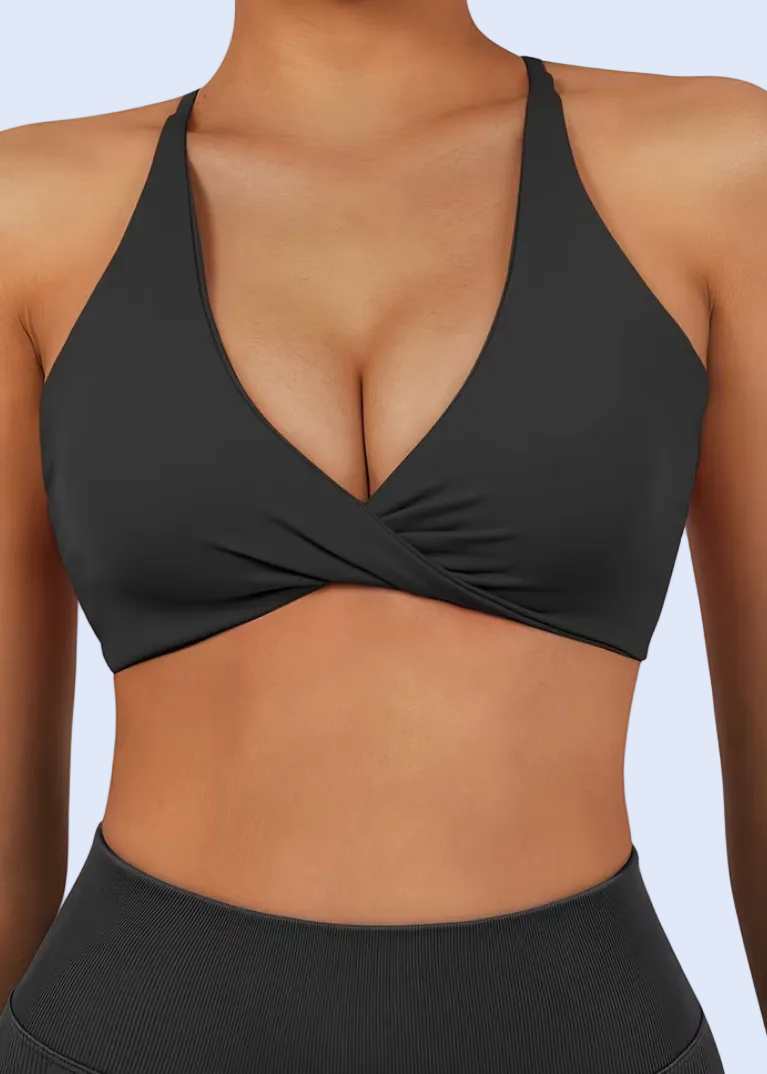 Person wearing a black sports bra and leggings on a white background