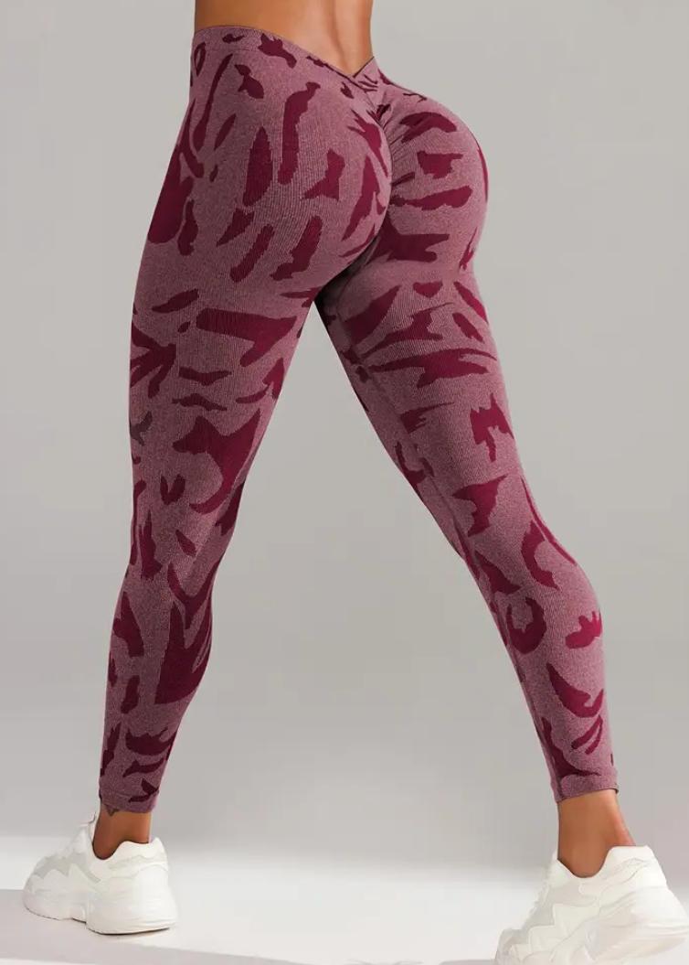 Maroon patterned leggings worn by a person on a gray background