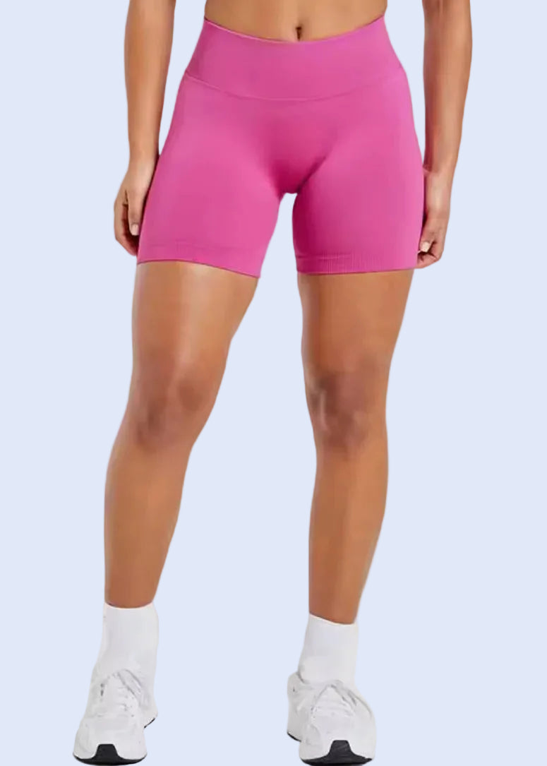 Person wearing pink gym shorts on a white background