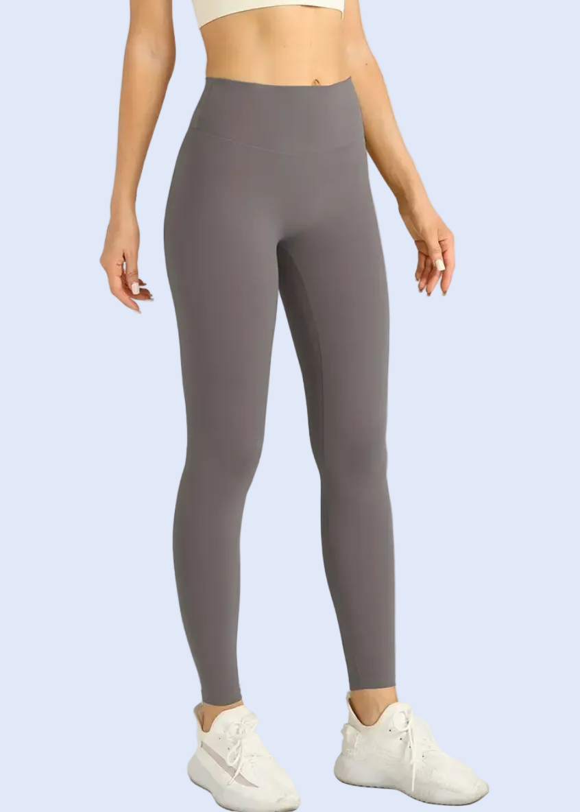 Person wearing gray leggings on a white background