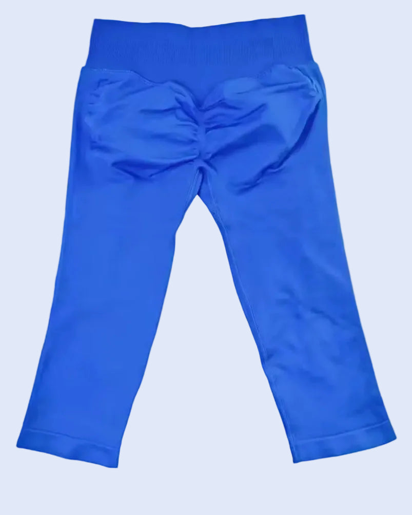 Bright electric blue leggings shown flat against a light neutral background, with a gathered ruched back detail and elastic waistband.