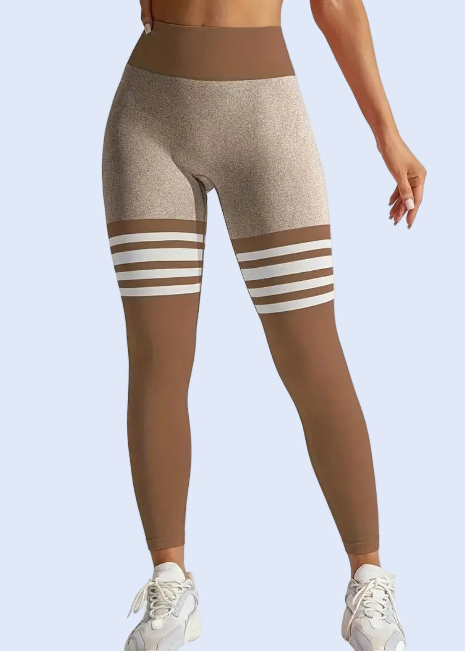 Beige leggings with white stripes worn by a person on a light gray background