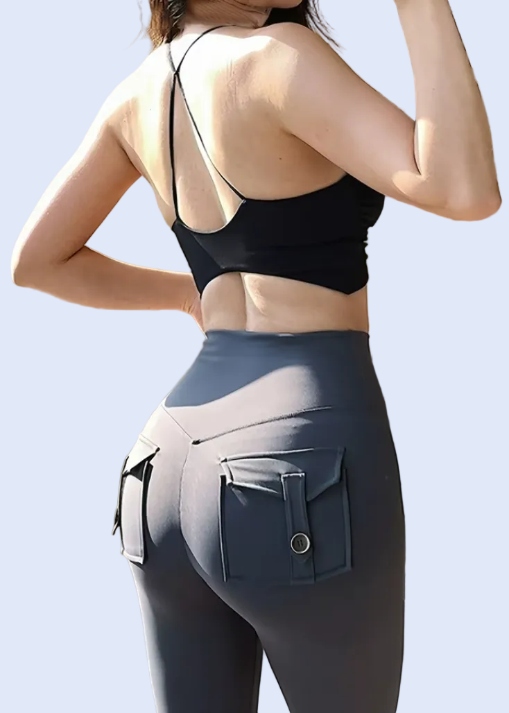 Person wearing a black sports bra and gray leggings with a pocket, standing outdoors.