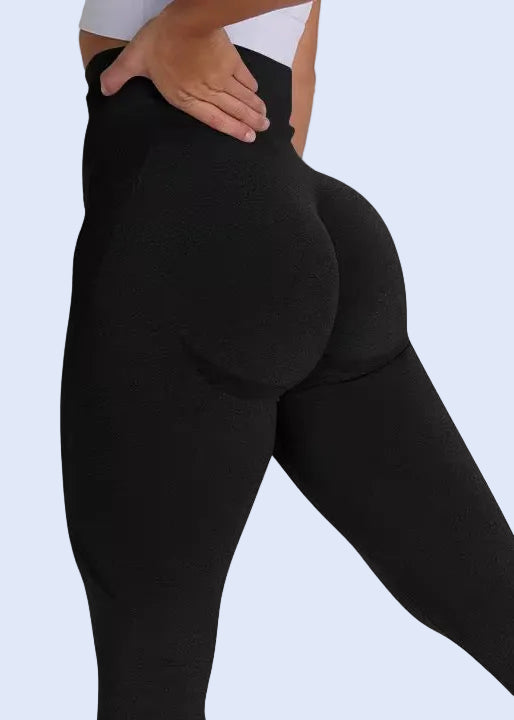 Person wearing black leggings and white sneakers on a white background