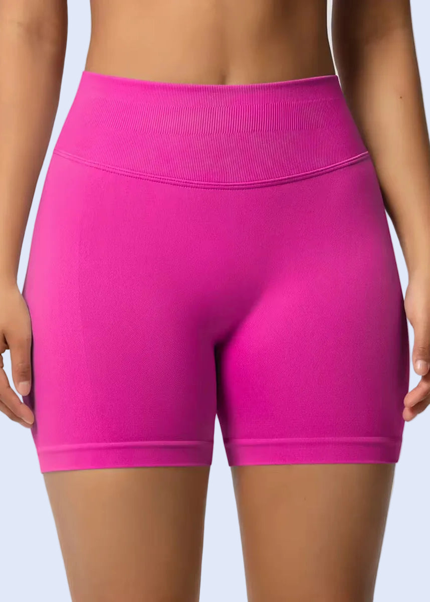 Pink athletic shorts worn by a person on a plain background