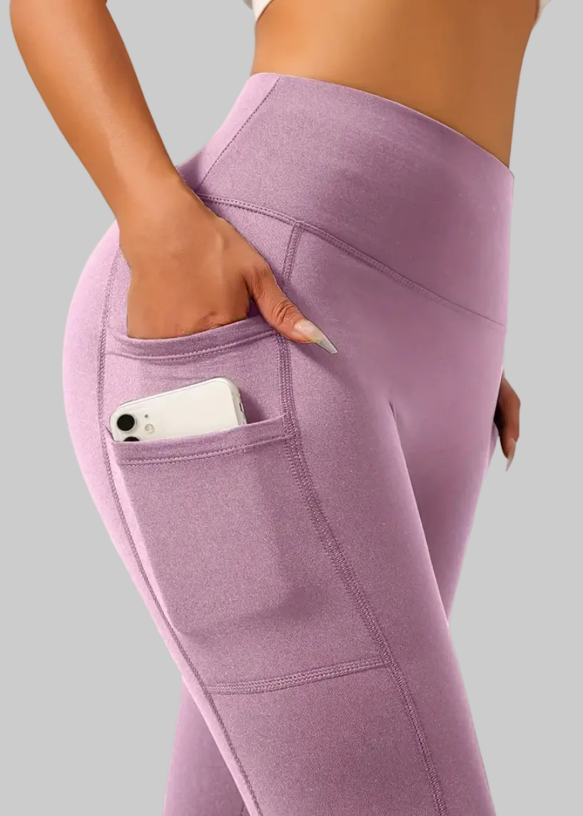 Purple leggings with a pocket on a plain background