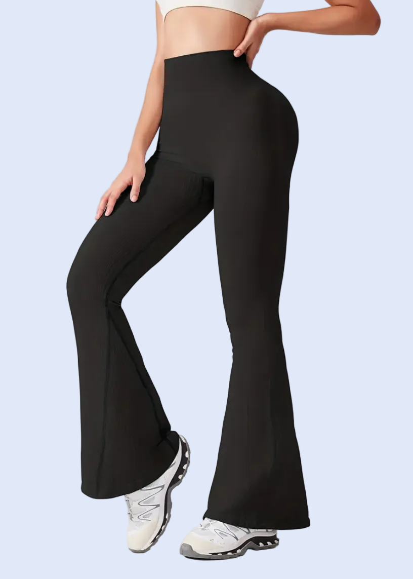 Person wearing black flared pants on a white background