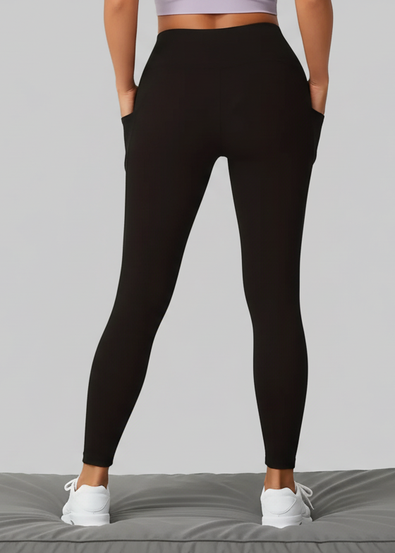 Person wearing black leggings on a beige background