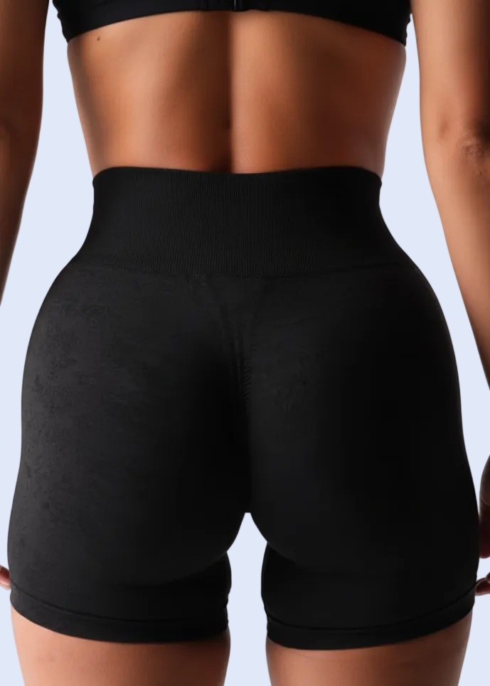 Person wearing black athletic shorts on a plain background