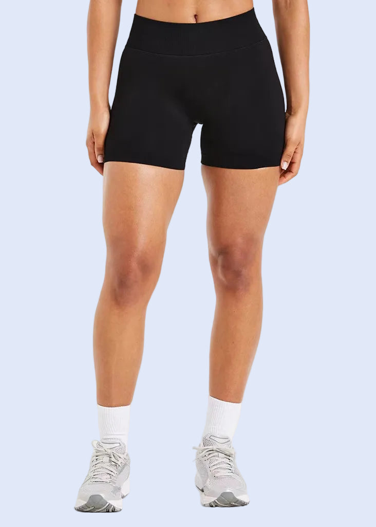 Person wearing black athletic shorts on a white background