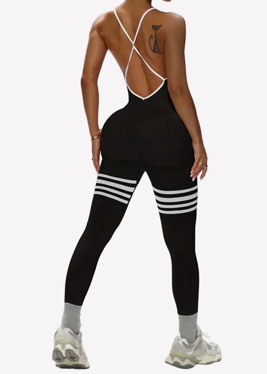 Person wearing a black outfit with white stripes on a plain background