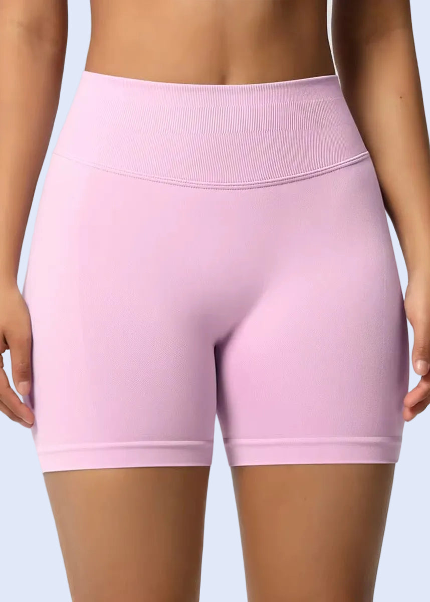 Pink athletic shorts worn by a person on a plain background