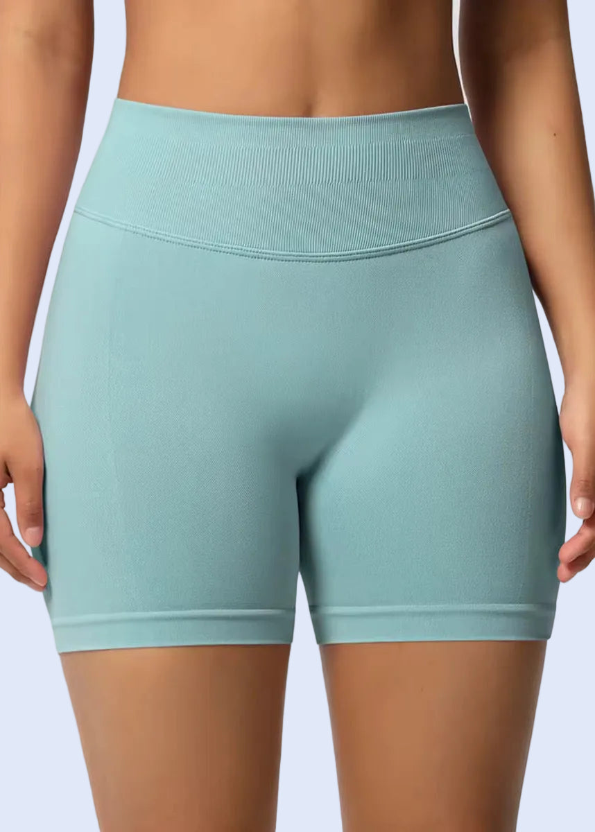 Teal athletic shorts worn by a person on a plain background