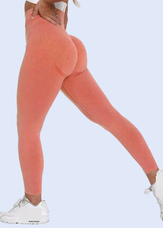 Person wearing coral leggings and white sneakers on a white background