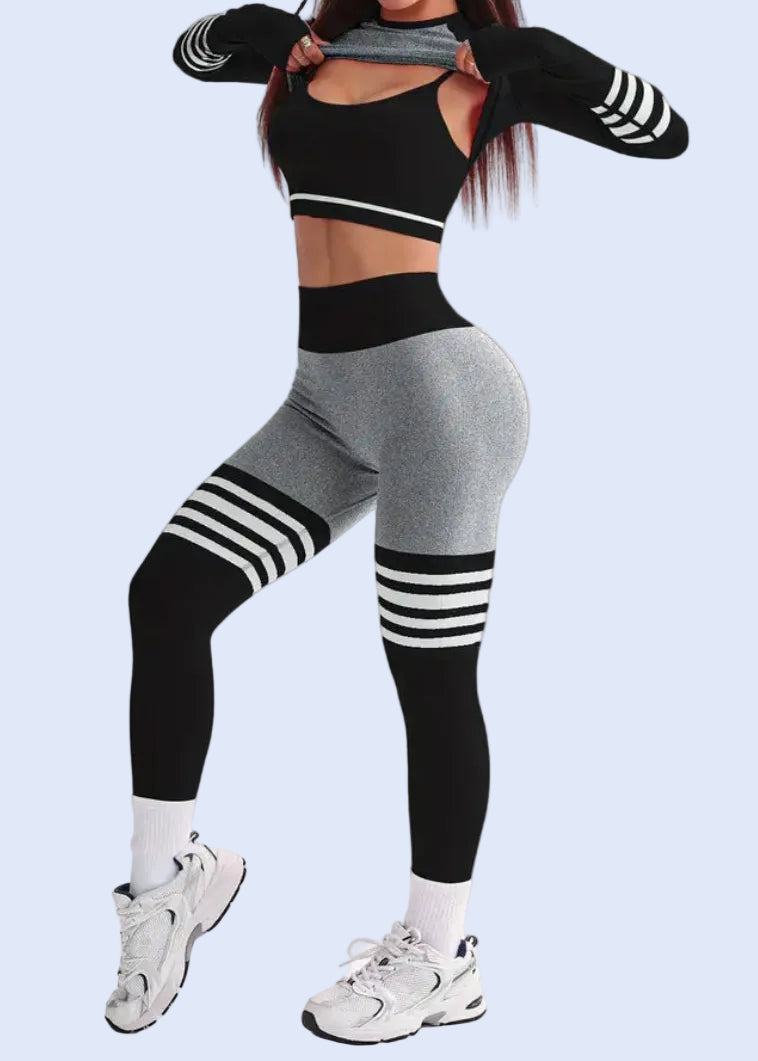 Woman in black and gray athletic outfit posing on a white background