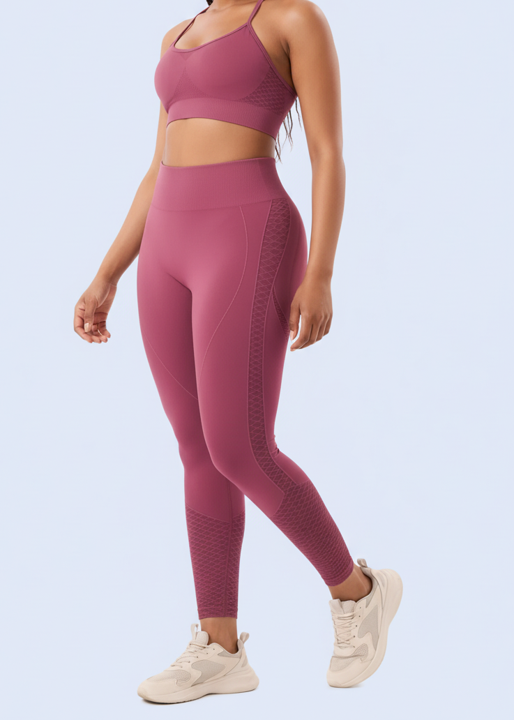 Woman in a pink athletic outfit standing against a white background