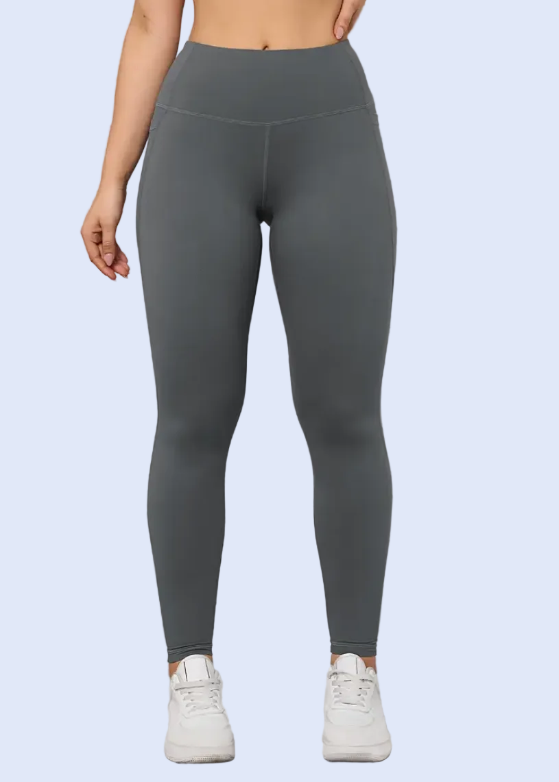 Person wearing gray leggings against a white wall