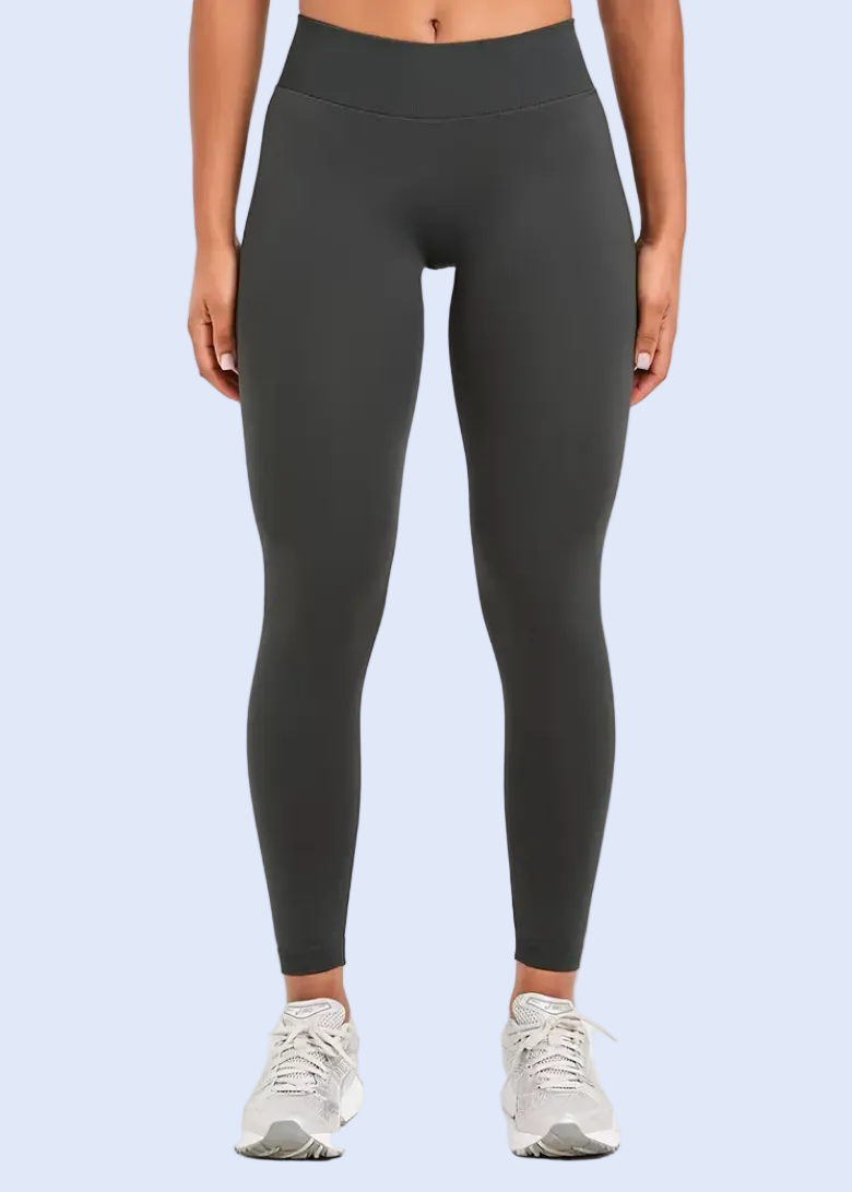 Person wearing dark gray leggings on a white background