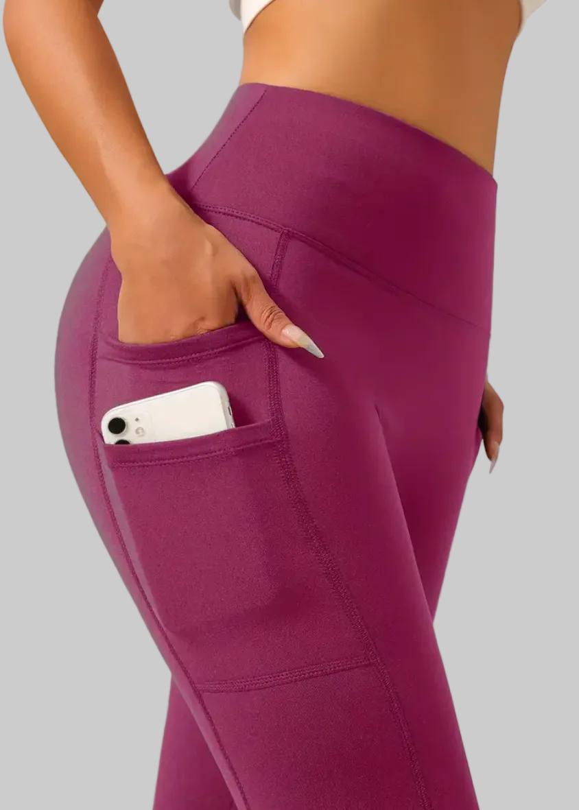 Purple leggings with a pocket holding a phone on a beige background