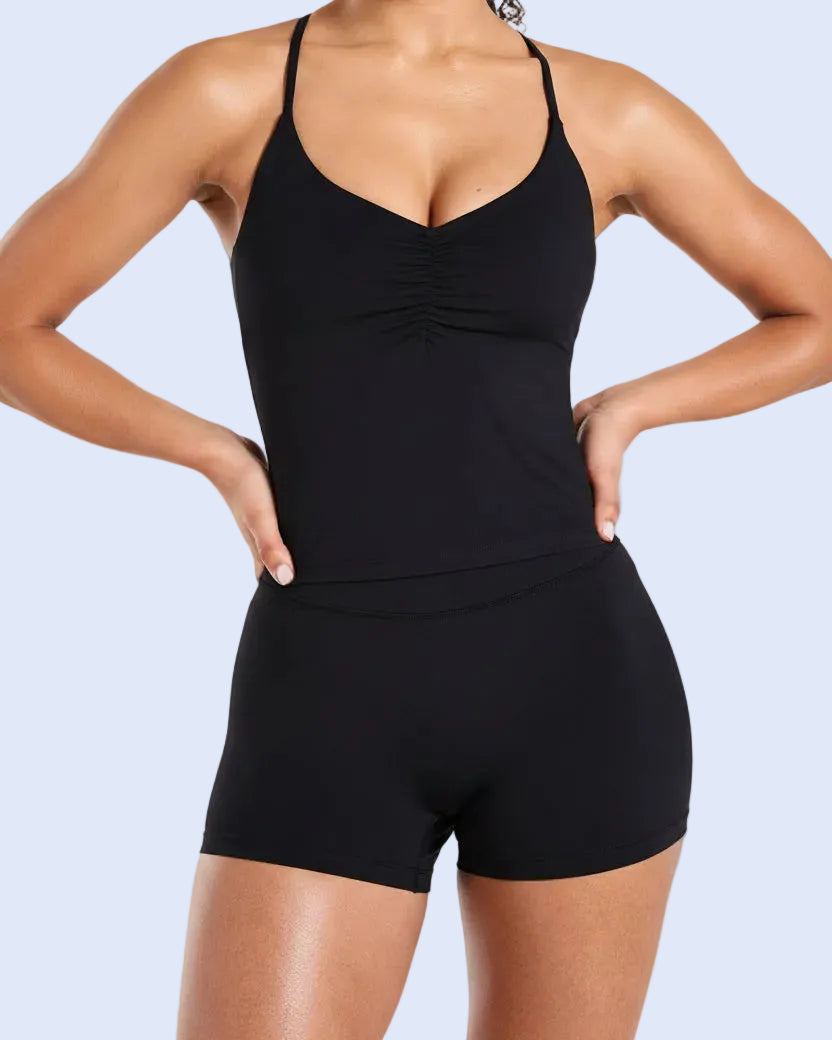 Woman wearing a black swimsuit with a plain background