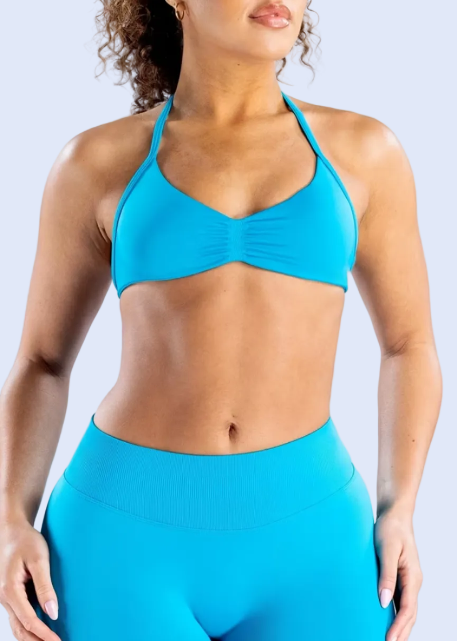 Person wearing a blue sports bra and leggings on a white background