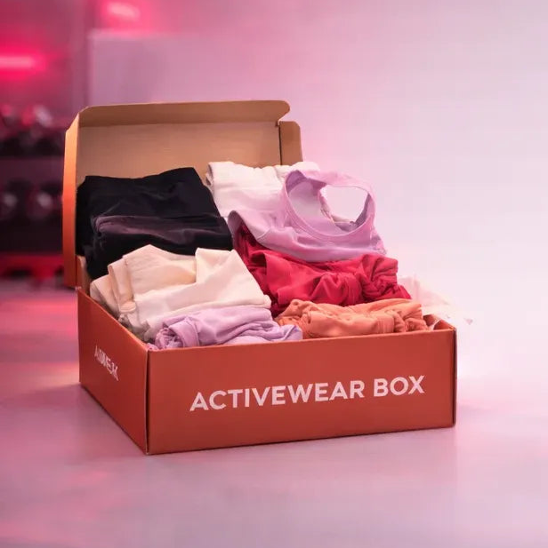 Open activewear box with clothes on a blurred background